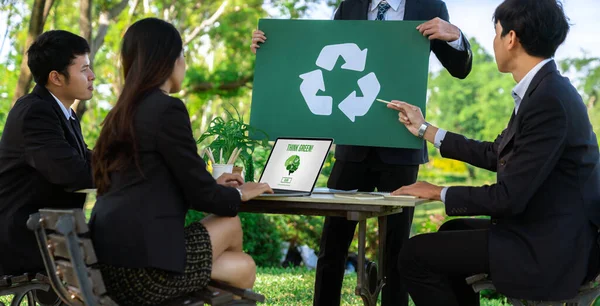 Group of businesspeople meeting at outdoor office in the nature planning and brainstorming on recycle strategy for greener environment by reducing and reusing recyclable waste. Gyre