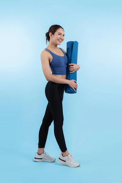 Stock image Young attractive asian woman portrait in sportswear with exercising mat. Healthy exercise and workout routine lifestyle concept. Studio shot isolated background. Vigorous