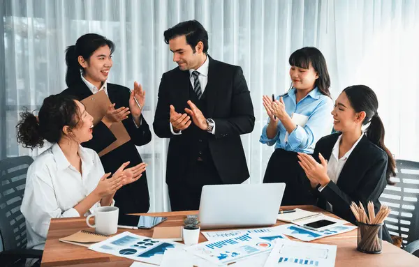 Group of happy businesspeople in celebratory gesture and successful efficient teamwork. Diverse race office worker celebrate after made progress on marketing planning in corporate office. Habiliment