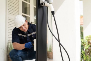 Nitelikli teknisyenler ev EV şarj istasyonu kurarak elektrikli araçların şarj platformu için bakım hizmeti sağlıyorlar. Konut kullanımı için EV araba teknolojisi. Eşzamanlama