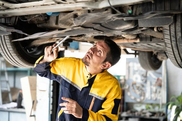 Mechanik Vozidla Provádí Kontrolu Zpod Zdviženého Vozidla Automobilový Servisní Technik — Stock fotografie
