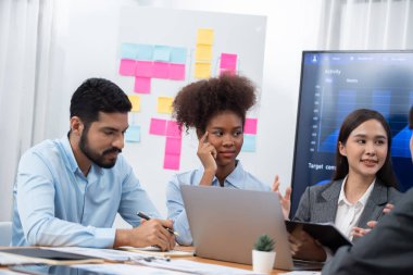 Çok ırklı analist ekibi toplantı masasındaki mali raporu analiz etmek için BI gösterge tablosunu kullanıyor. Çeşitli iş adamlarından oluşan bir grup, FIntech 'in veri analizini başarılı iş pazarlaması için kullanır. Uyum