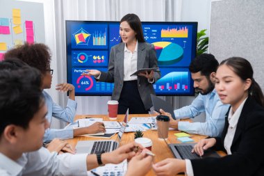 Genç Asyalı iş kadını modern toplantıda TV ekranında veri analizi paneli sunuyor. Bir grup iş adamıyla konferans odasında iş sunumu. Uyum