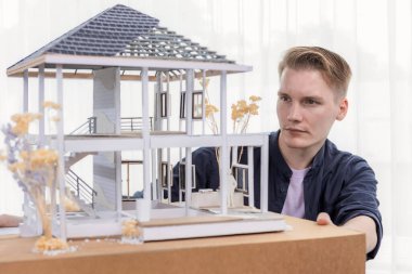 Mimari tasarımcı ev iskeleti modelini duvarsız gözden geçiriyor, iç tasarımda beyin fırtınası yapıyor ve gerçek ev ölçeğinde geliştirme fikri geliştiriyor. Mimari tasarımda profesyonellik ve yaratıcılık. Tekrarlama