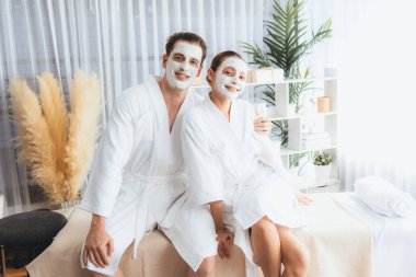 Yüzü kremli, bornozlu mutlu bir çift tatil boyunca kaplıca salonu ya da otelin huzurlu atmosferinin tadını çıkarıyor. Şımarık yüz spa 'sı ve cilt bakımı, esans rahatlığı. Sessiz.