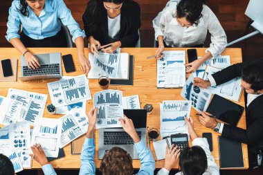 Panorama üst düzey iş analist grubu toplantı masasındaki finansal veri raporunu analiz ediyor. İş zekası analizine göre çizelge ve grafik paneli. Çok titiz.