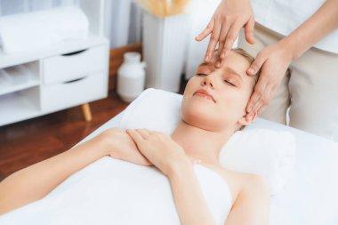 Kafkasyalı kadın stres önleyici kafa masajından ve lüks tatil beldesi ya da otel spa salonundaki modern ışık ortamında yüz güzelliği eğlencelerini şımartmaktan hoşlanıyor. Sessiz.