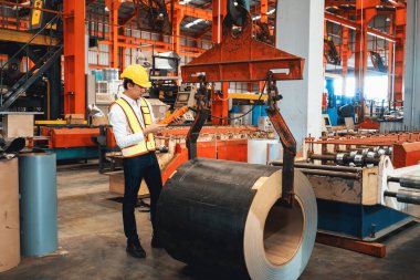 Makine operatörü çelik üretim makinelerini ustalıkla çalıştırıyor, metal fabrikasındaki ağır inşaat mühendisliği malzemeleri için silindir rulo çelik üretiyor. Örnek gösteriliyor