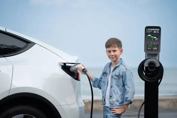 Mały Chłopiec Ładujący Ekologiczny Elektryczny Samochód Stacji Ładowania Podróż Samochodem — Zdjęcie stockowe