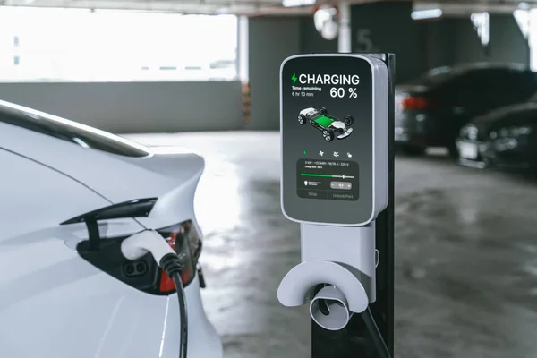 市内のショッピングセンター駐車場でEv電気自動車の充電を行い 電気自動車旅館の緑豊かな再充電可能エネルギーによる都市持続可能性のライフスタイルを示しています — ストック写真