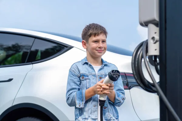 Mały Chłopiec Ładujący Ekologiczny Elektryczny Samochód Stacji Ładowania Koncepcja Podróży — Zdjęcie stockowe