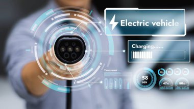 Kameranın önündeki EV şarj aletine odaklan. Bulanık arka planda akıllı batarya durum hologramını göster. Karbondioksit salınımını azaltmak için temiz enerji kullanan elektrikli araba şarjı.