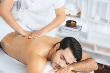 Kafkas erkek müşteri stres önleyici spa masajının keyfini çıkarıyor ve lüks otel veya oteldeki gündüz açık hava ortamında güzellik derisi eğlencesi ile şımartıyor. Sessiz.