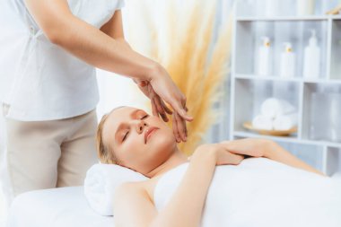 Kafkasyalı kadın stres önleyici kafa masajından ve lüks tatil beldesi ya da otel spa salonundaki modern ışık ortamında yüz güzelliği eğlencelerini şımartmaktan hoşlanıyor. Sessiz.