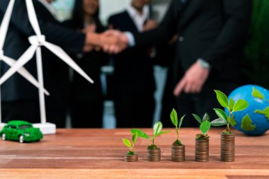 Organik para büyüme yatırım konsepti, üzerinde filiz veya bebek bitkisi olan para yığınlarının istiflenmesi ile gösterilir. Finansal yatırımlar, doğayla birlikte sürdürülebilir temiz enerjinin kökünü kazıdı ve geliştirdi. Antika