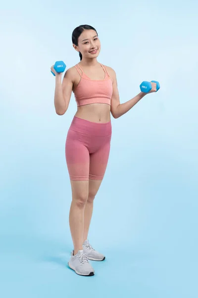 隔離された背景で運動を持ち上げるダンベル重量を行っている活発な女性 ボディワークアウトルーチンとしての若い運動アジアの女性の強さと耐久トレーニングセッション — ストック写真