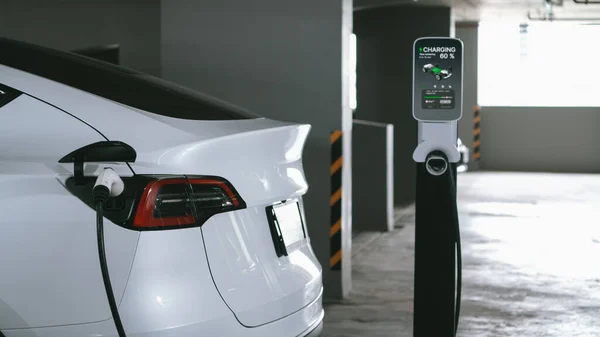 Електричний Автомобіль Заряджається Парковці Центрі Міста Показуючи Міський Стиль Життя — стокове фото