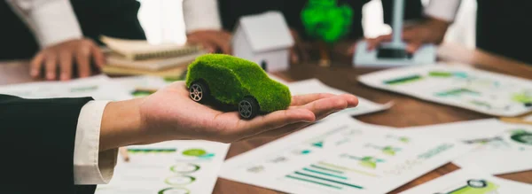 在电动汽车公司的会议上 持绿色电动汽车模型的商人进行了模拟 商界人士规划了使用无污染清洁能源的环保汽车产品的战略营销 开拓创新 — 图库照片