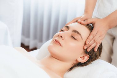 Kafkasyalı kadın stres önleyici kafa masajından ve lüks tatil beldesi ya da otel spa salonundaki modern ışık ortamında yüz güzelliği eğlencelerini şımartmaktan hoşlanıyor. Sessiz.