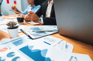 Ofis masasındaki finansal veri raporlarını analiz eden çeşitli bir grup iş analisti. Stratejik pazarlama planlaması için iş istihbarat analizine göre grafikler ve grafikler.