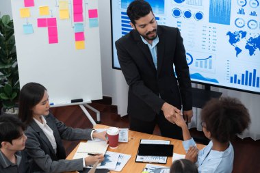 Çeşitli iş arkadaşları bunu şirket işyerinde el sıkışma ve takım çalışmasıyla kutluyor. Başarılı bir toplantıdan sonra el sıkışmayla ya da veri analizi üzerine iş sunumuyla birleşen mutlu iş adamları. Uyum