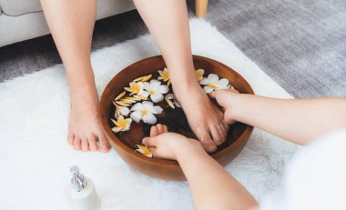 Kadınlar lüks spa salonlarında keyifli ayak masajlarına devam ederken, masör de hafif gün ışığı atmosferinde refleksoloji terapisi veya otel ayak spa 'sında. Sessiz.