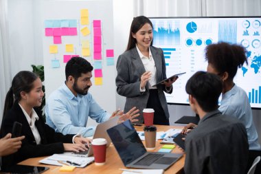 Genç Asyalı iş kadını modern toplantıda TV ekranında veri analizi paneli sunuyor. Bir grup iş adamıyla konferans odasında iş sunumu. Uyum