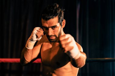 Üstsüz boksör pozu veren, beyaz boksör yumruğunu yumruklayıp kameranın önüne geçiyor, agresif duruşunu takınıyor ve boks ringinde dövüşmeye hazır. Impetus