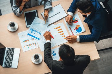 İş adamları grup toplantısı ofiste yukarıdan çekildi. İş kadınları, iş adamları ve ofis çalışanları toplantı masasında proje planlama belgeleriyle takım konferansında çalışıyorlar. Jivy