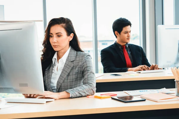 Modern ofis odasındaki masada çalışan iş adamları mali veri raporlarını incelerken. Jivy