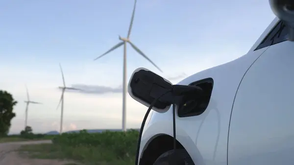環境保全のため 風力発電機によるグリーン 再生可能エネルギーを活用した充電ステーションにおいて 電気自動車の先進的な未来エネルギーインフラ構想 — ストック写真
