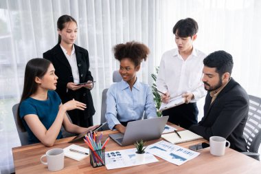 Çok ırklı analist ekibi toplantı masasındaki finansal verileri analiz etmek için BI Fintech yazılımı kullanıyor. Finansal konsol veri ekranında pazarlama göstergesi için analiz edilmiş grafikle birlikte. Uyum