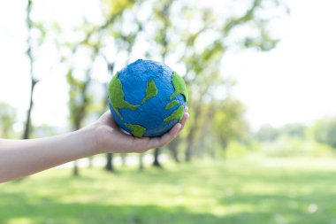 Dünya gezegenini ESG ilkesi ve çevre dostu enerjisiyle daha parlak bir gelecek için Dünya günü olarak el ele tutuşan genç çocuklar. Döngü