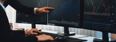 Bir grup tüccar ofis masasında tartışıyor, borsayı işyerinde monitörden izliyorlar. İşadamı ve borsacı borsa şirketinde hisse senedi grafiğini birlikte analiz ediyorlar. Önde.