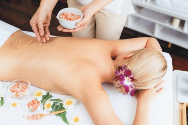 Lüks spa salonlarında sıcak mum ışığında cilt bakımı yaptıran kadın müşteri. Sağlık Spa vücut fırçasında tuz temizleme güzellik tedavisi. Sessiz.