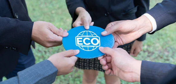 Business people holding ECO friendly idea symbol together as group of eco professional teamwork concept to promote social awareness on environmental protection. Gyre