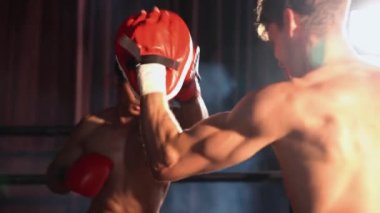 Asyalı ve Kafkasyalı Muay Thai boksörü boks antrenmanında boks antrenmanında boks antrenörüne yumruk atma, Muay Thai boks tekniği ve becerilerini sergileme. Impetus