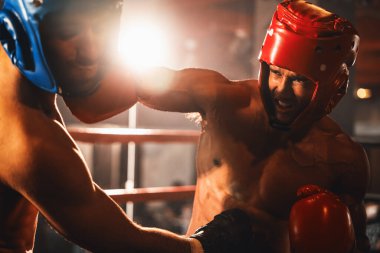Kasklı iki atletik ve kaslı vücut boksörü ya da boks baş muhafızı vahşi bir boks maçında karşı karşıya. Boks dövüşçüsü boks ringinde dövüşüyor. Impetus