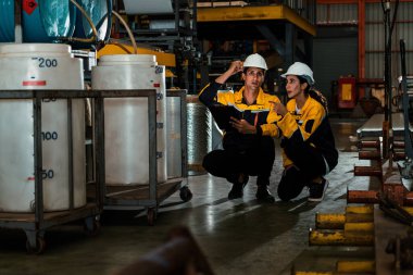 İki fabrika işçisi veya mühendis, kimya fabrikası, kimya fabrikası işyeri ve endüstriyel meslek konseptinde makine veya prosedür üzerinde profesyonel teftiş yürütüyor. Örnek gösteriliyor