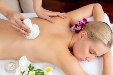 Sıcak bitkisel top spa masaj vücut tedavisi, masör kadın vücuduna nazikçe şifalı bitki torbası bastırıyor. Aromaterapi dinlenme sükuneti ve sükuneti kaplıca salonundaki atmosferi aydınlatıyor. Sessiz.