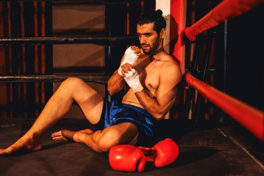 Şiddetli boks antrenmanı ve dövüş müsabakasından sonra acı ve sakatlığı olan beyaz bir boksör ringin kenarında oturuyor. Spor konseptinde fiziksel yaralanma. Impetus