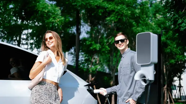 Junges Paar Reist Mit Elektroauto Aufladung Grünen Nachhaltigen Stadtgarten Sommer — Stockfoto