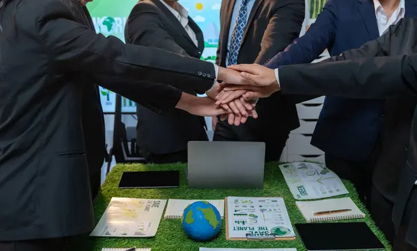 Business synergy of business people holding hand together as team building for eco regulation for environmental protection by reducing CO2 emission to contribute sustainable future. Quaint
