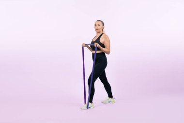 Vücut uzunluğu tam, atletik ve sportif yaşlı kadın izole arka planda fitness direnci bandı var. Emeklilikten sonra sağlıklı, aktif bir fiziğe ve vücut bakımına sahip. Etki