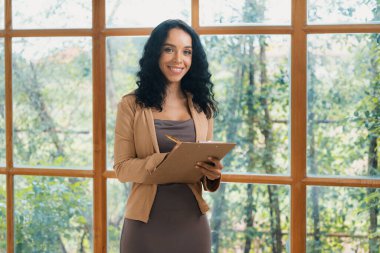 Klinikteki psikolog kadın. Profesyonel portresi. Dostane gülümsemesiyle hastayı psikoloğa davet ediyor. Deneyimli ve kendinden emin psikolog çok önemli bir uzmandır.