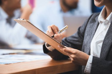 Analist ekibi toplantı masasındaki mali raporu incelemek için BI gösterge tablosu verilerini kullanarak yazma ve pazarlama planlıyor. İş adamları iş kararı için FIntech 'in veri analizinden faydalanıyor. Uyum