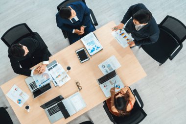 İş adamları grup toplantısı ofiste yukarıdan çekildi. İş kadınları, iş adamları ve ofis çalışanları toplantı masasında proje planlama belgeleriyle takım konferansında çalışıyorlar. Jivy