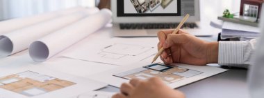 Masanın iç mimar tasarımcısı, mimari yazılımlar kullanarak ev içi çizim taslağı tasarlıyor, modern ev yenileme tasarımı için ruh hali tahtası örnekleri seçiyor. İçgörü