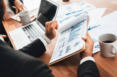 Ofis masasındaki finansal veri raporlarını analiz eden çeşitli bir grup iş analisti. Stratejik pazarlama planlaması için iş zekası analizi çizelgesi ve grafiği.
