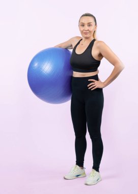 Vücut uzunluğu tam, atletik ve sportif yaşlı bir kadın izole edilmiş arka planda spor topuyla egzersiz yapıyor. Emeklilikten sonra sağlıklı ve aktif bir yaşam tarzı. Etki